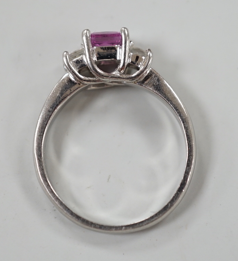 A modern platinum, single stone square cut pink sapphire and two stone diamond set ring, size N/O, gross weight 5.5 grams.